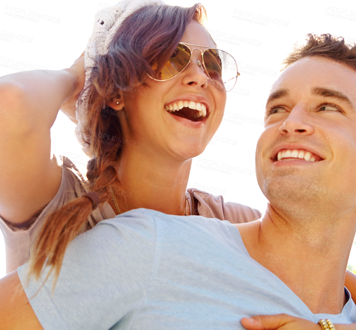 Buy stock photo Close up of a laughing girlfriend getting a piggyback from her boyfriend