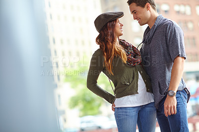 Buy stock photo A stylish couple looking at each other lovingly while standing outside with copyspace