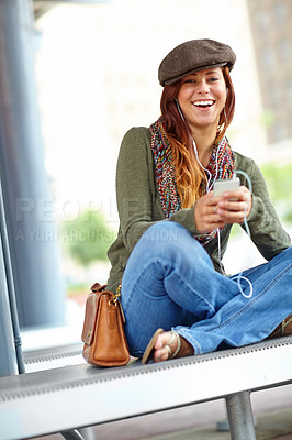 Buy stock photo Train station, woman and smile on smartphone with earphones for streaming music in Spain. Female person, portrait and happy with texting on internet, social media and message for communication