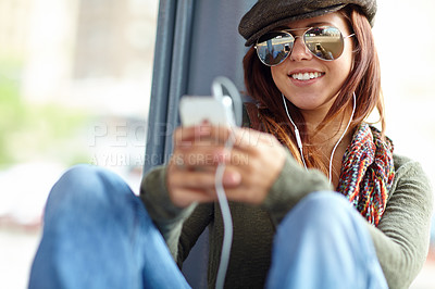 Buy stock photo Happy, train and woman with cellphone, listening to music and commute with sound, typing and smile. Person, traveller or girl with smartphone, mobile user or audio relaxing with podcast or connection