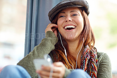 Buy stock photo Close up of a laughing beautiful girl listening to music on her phone