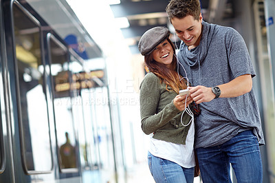 Buy stock photo Travel, music and platform with couple at bus station for holiday, streaming and journey together. Audio, public transportation and podcast with people at subway for support, adventure and date