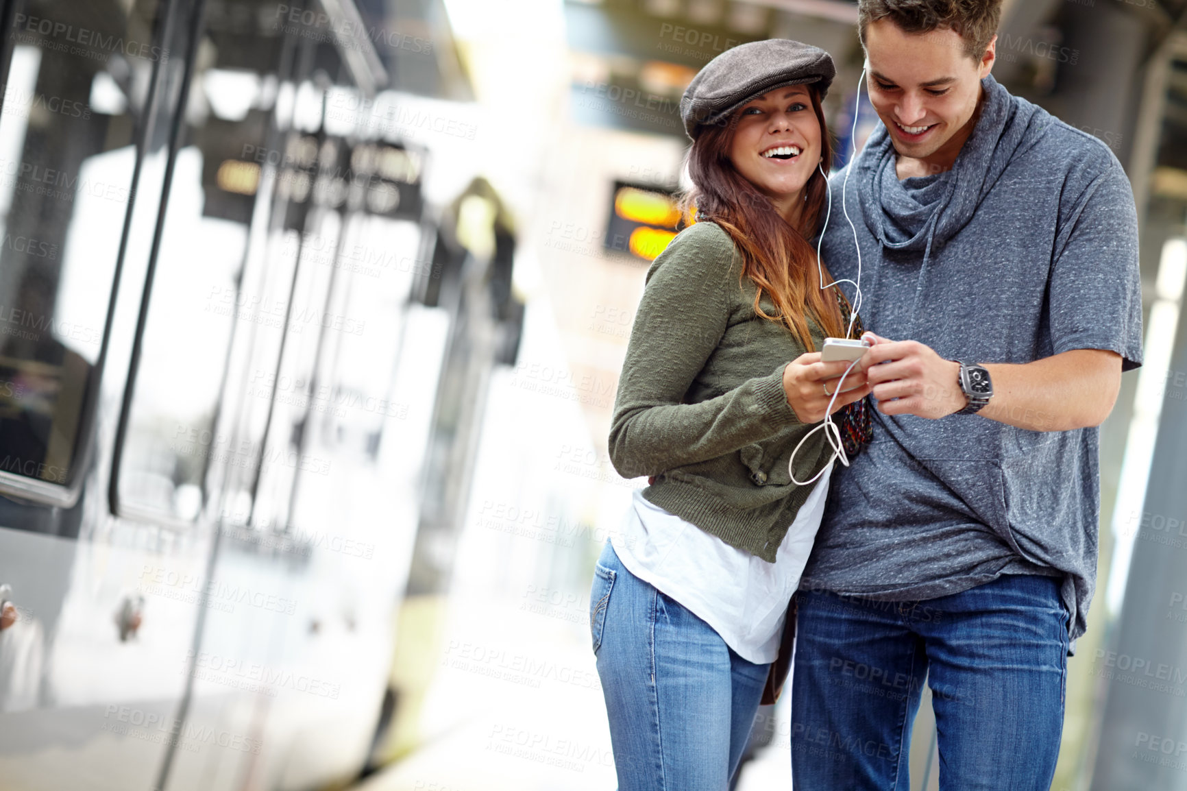 Buy stock photo Smile, music and platform with couple at bus station. for holiday,  streaming and journey together. Audio, public transportation and podcast with people at subway for support, adventure and date