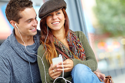 Buy stock photo A happy couple listening to music on a phone together with copyspace
