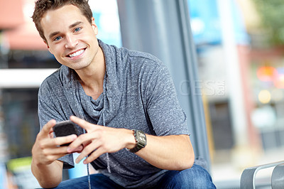Buy stock photo Portrait of a good looking man typing on his cellphone with copyspace