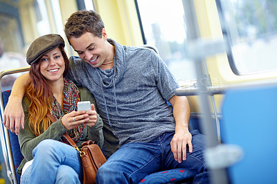 Buy stock photo Couple, phone and smile on train for travel, journey and happy in relationship. Woman portrait, man and mobile on public transport for ride schedule, booking accommodation and connectivity on holiday