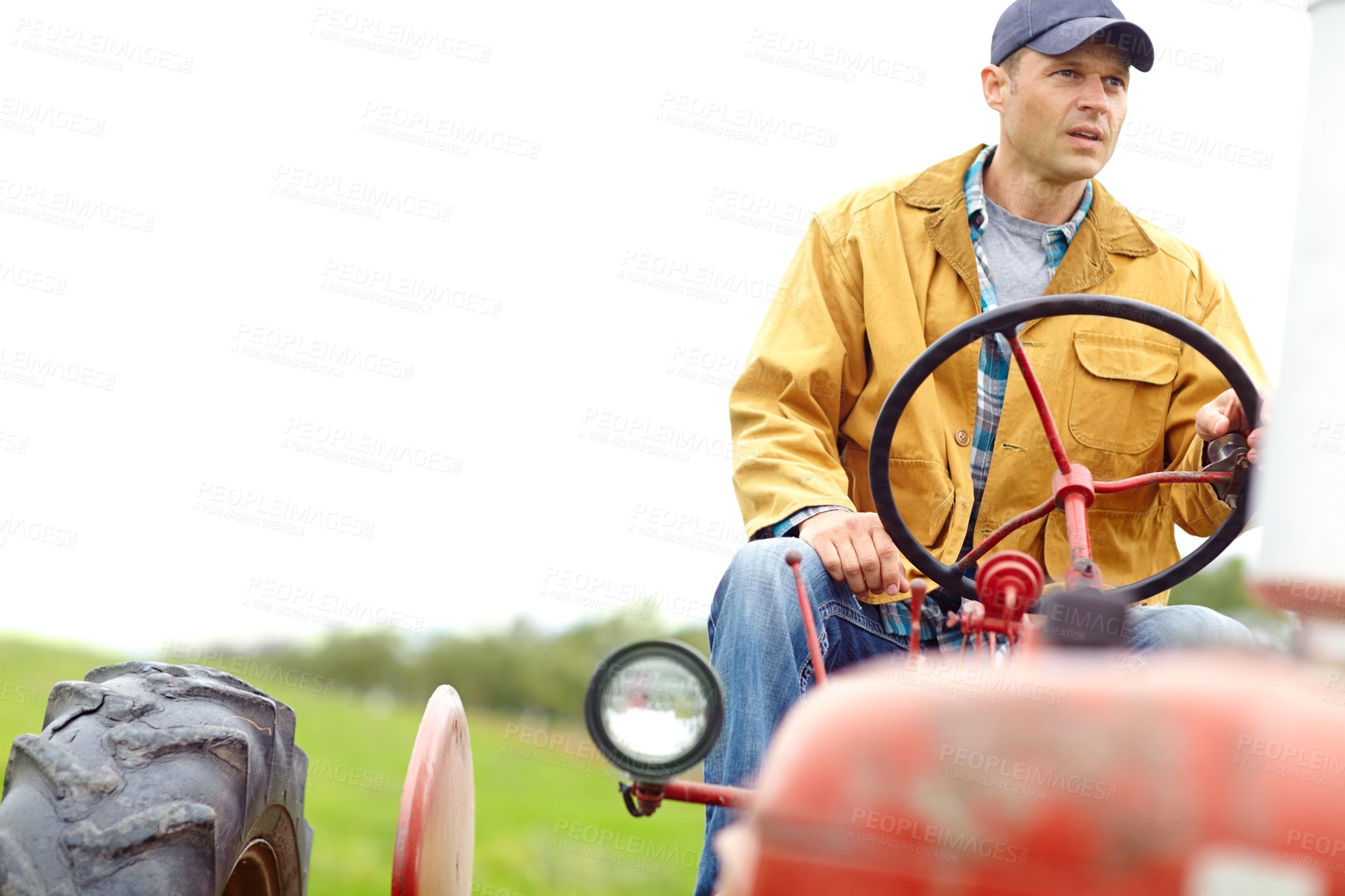Buy stock photo A farmer driving his tractor on an open field