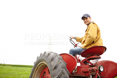 Buy stock photo Rearview of a smiling farmer driving his tractor on an open field with copyspace