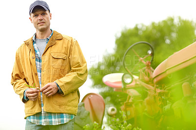 Buy stock photo Portrait of a farmer standing next to his tractor in a field