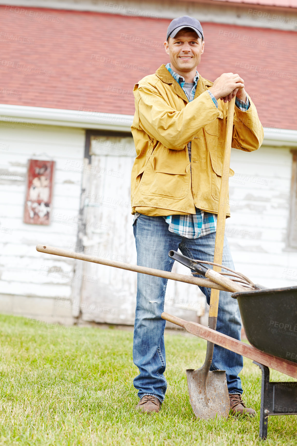 Buy stock photo Outdoor, shovel and happy man in portrait with wheelbarrow, farming and agriculture with pride by shed. Countryside, male person and farmer with equipment for transport, cleaning and spade as tools