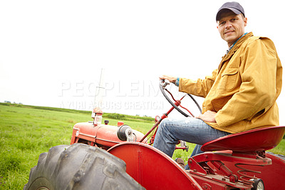 Buy stock photo A farmer sitting on his tractor and looking at the camera on an open field with copyspace