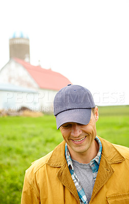 Buy stock photo A mid adult farmer standing on the farm with the farm house in the background