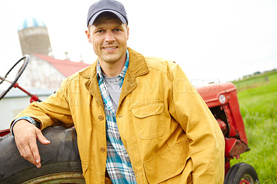 Buy stock photo A mid adult farmer leaning against a tractor on his farm