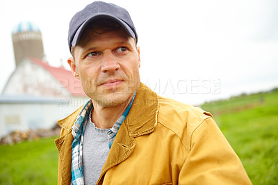 Buy stock photo A frowning mid adult farmer looking away while on his farm - Cropped