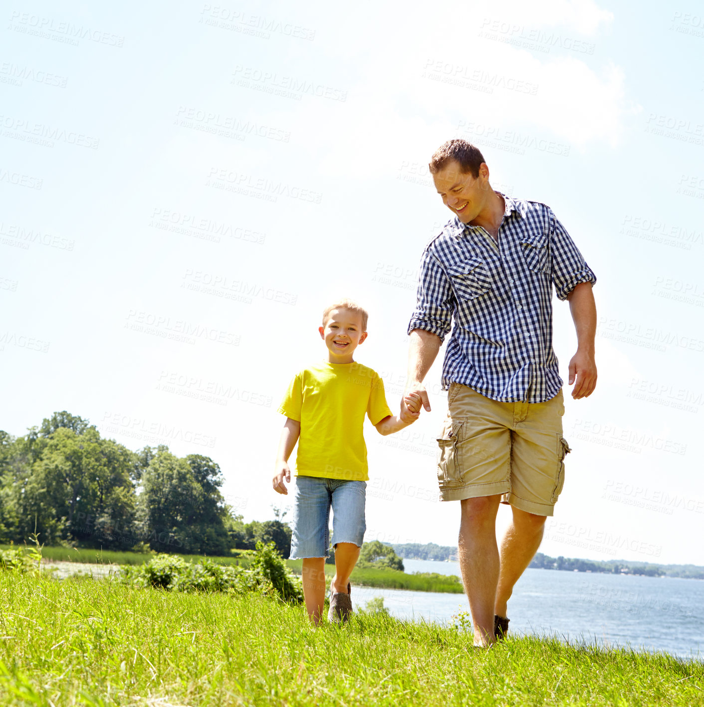 Buy stock photo Young father and son walking by the lake while holding hands