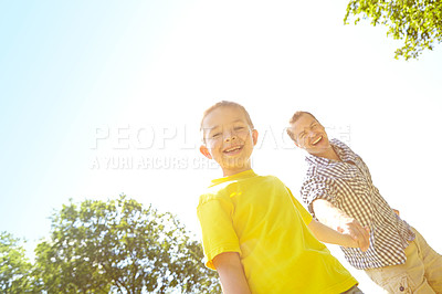 Buy stock photo Cute young boy smiling widely and looking at the camera while holding his dad's hand
