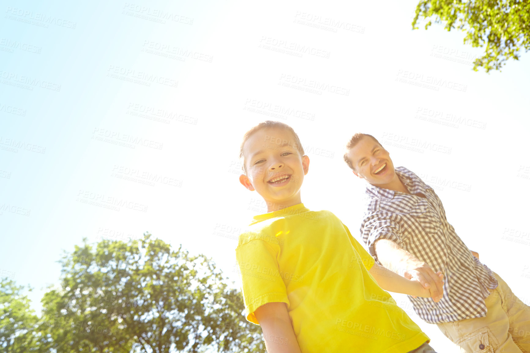 Buy stock photo Outdoor, dad and happy on holding hands with boy for bonding, fun or support in England. Low angle, parent and smile with kid at park for love, trust or care as family for child development or growth