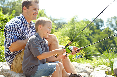 Buy stock photo Side view of a father sitting and fishing with his son