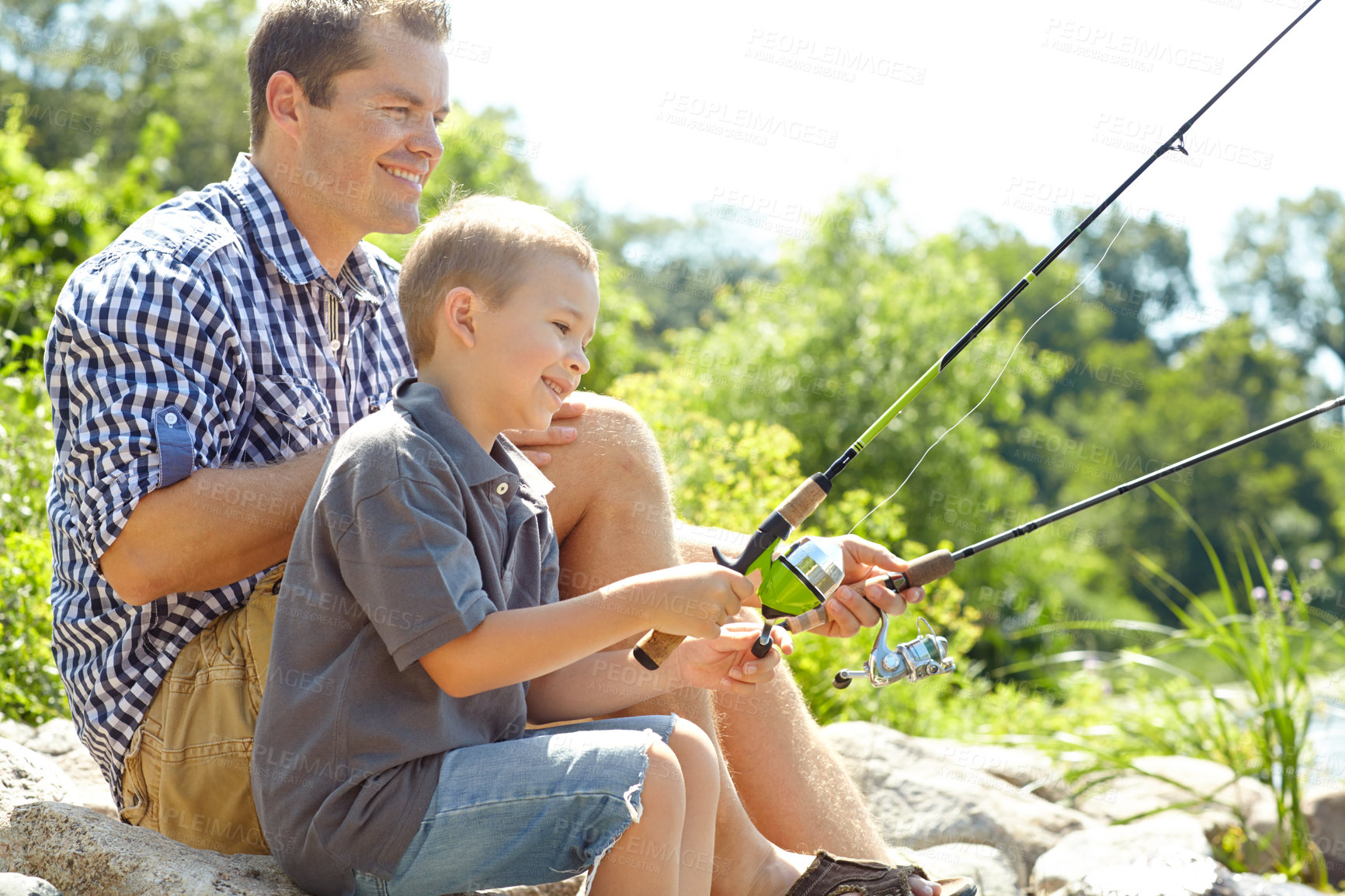 Buy stock photo Side view of a father sitting and fishing with his son