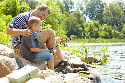 Buy stock photo Side view of a father teaching his son how to fish