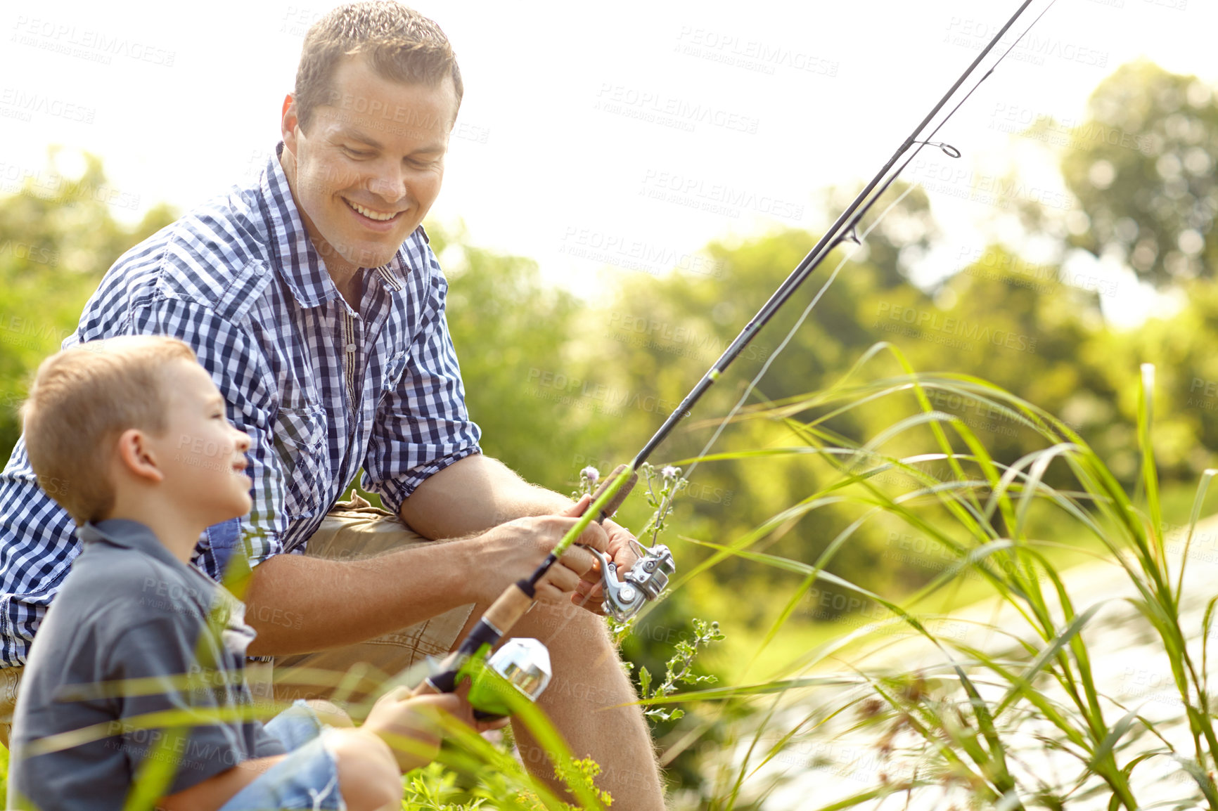 Buy stock photo Dad, son and smile with fishing at lake with help for support, bonding or care in Australia. People, parent and happy with kid at river with teaching, learning or skill as family tradition for growth