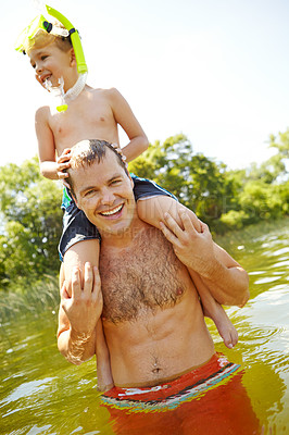 Buy stock photo Young father in a lake carrying his son on his shoulders while smiling