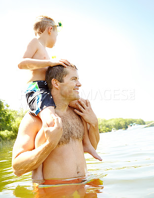 Buy stock photo Cute young boy sitting on his dad's shoulders while wearing a snorkel and mask