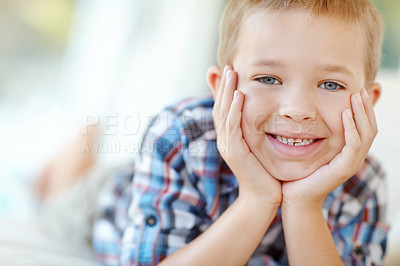 Buy stock photo Smile, sweet and portrait of kid in home with positive attitude for childhood development. Happy, cute and face of young adorable boy from Germany with relaxing on sofa in living room at house.