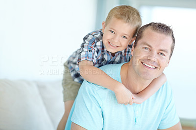 Buy stock photo Boy, dad and piggy back in portrait in home with smile, bonding and love for games, funny or connection on sofa. Child, father and happy with comic memory, hug and relax at family house in Germany