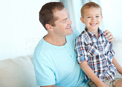 Buy stock photo Boy, father and hug on sofa in home for portrait, bonding or love with support for connection in morning. Child, dad and happy man with security, pride and relax in lounge at family house in Germany