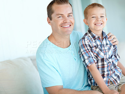 Buy stock photo Boy, father and hug on couch in home for portrait, bonding or love with support for connection in morning. Child, dad and happy man with security, pride and relax in lounge at family house in Germany