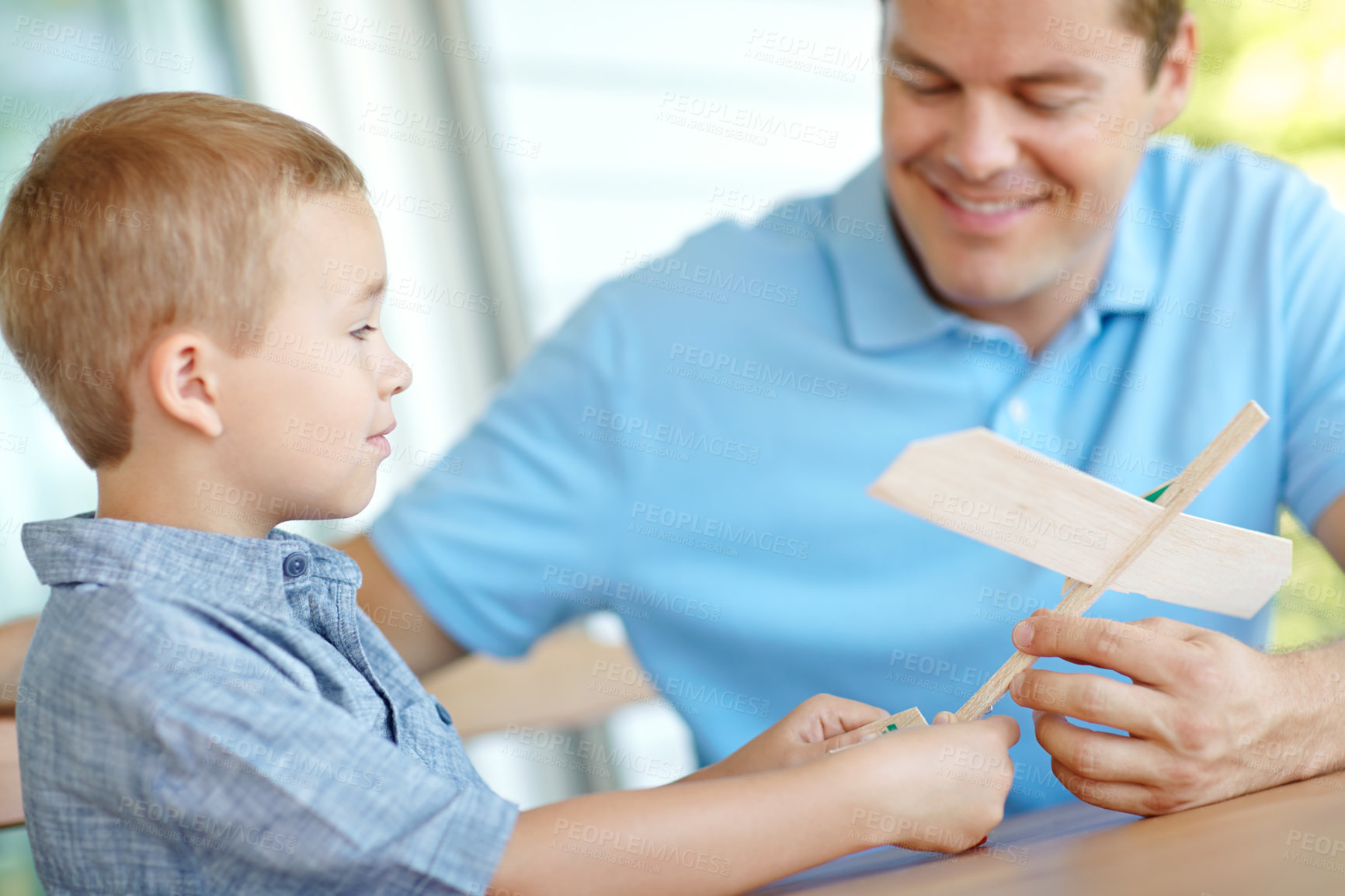 Buy stock photo Airplane, building and dad with child in home with toys for bonding, relationship and development. Family, creative and father with boy for model aeroplane for games, entertainment and relax in house