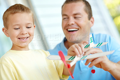 Buy stock photo Airplane, playing and dad with kid in home with toys for bonding, relationship and development. Family, creative activity and boy building model aeroplane for fun games, entertainment and relax