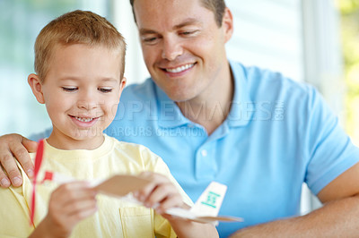 Buy stock photo Airplane, toys and child and dad in home for fun for bonding, relationship and creativity. Family, happy and boy building model aeroplane with father for games, entertainment and playing together