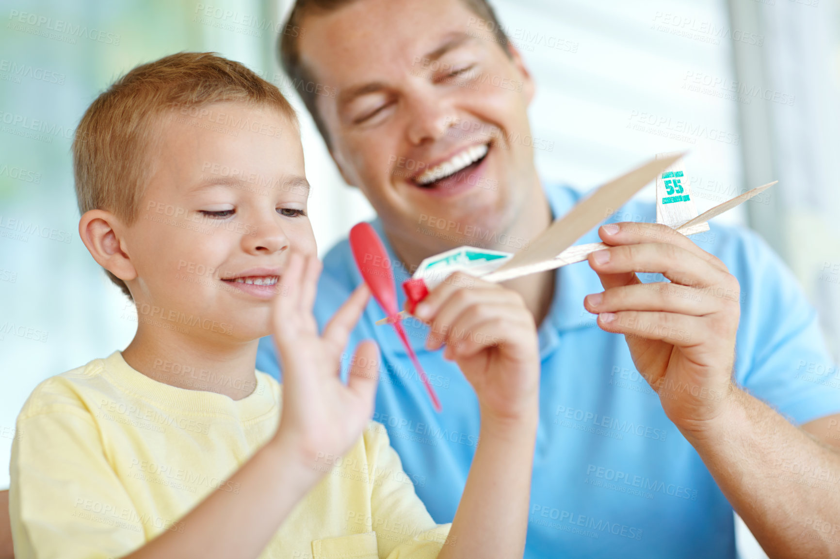 Buy stock photo Toys, airplane and playful boy with dad, smile and fun on patio together for morning bonding. Playing, weekend games and happy child in backyard with paper plane, father and son laughing in home