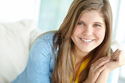 Buy stock photo Girl, portrait and teenager relax on couch, peace and confident adolescent in living room. Female person, comfortable child and proud smile on weekend in apartment, home and morning satisfaction