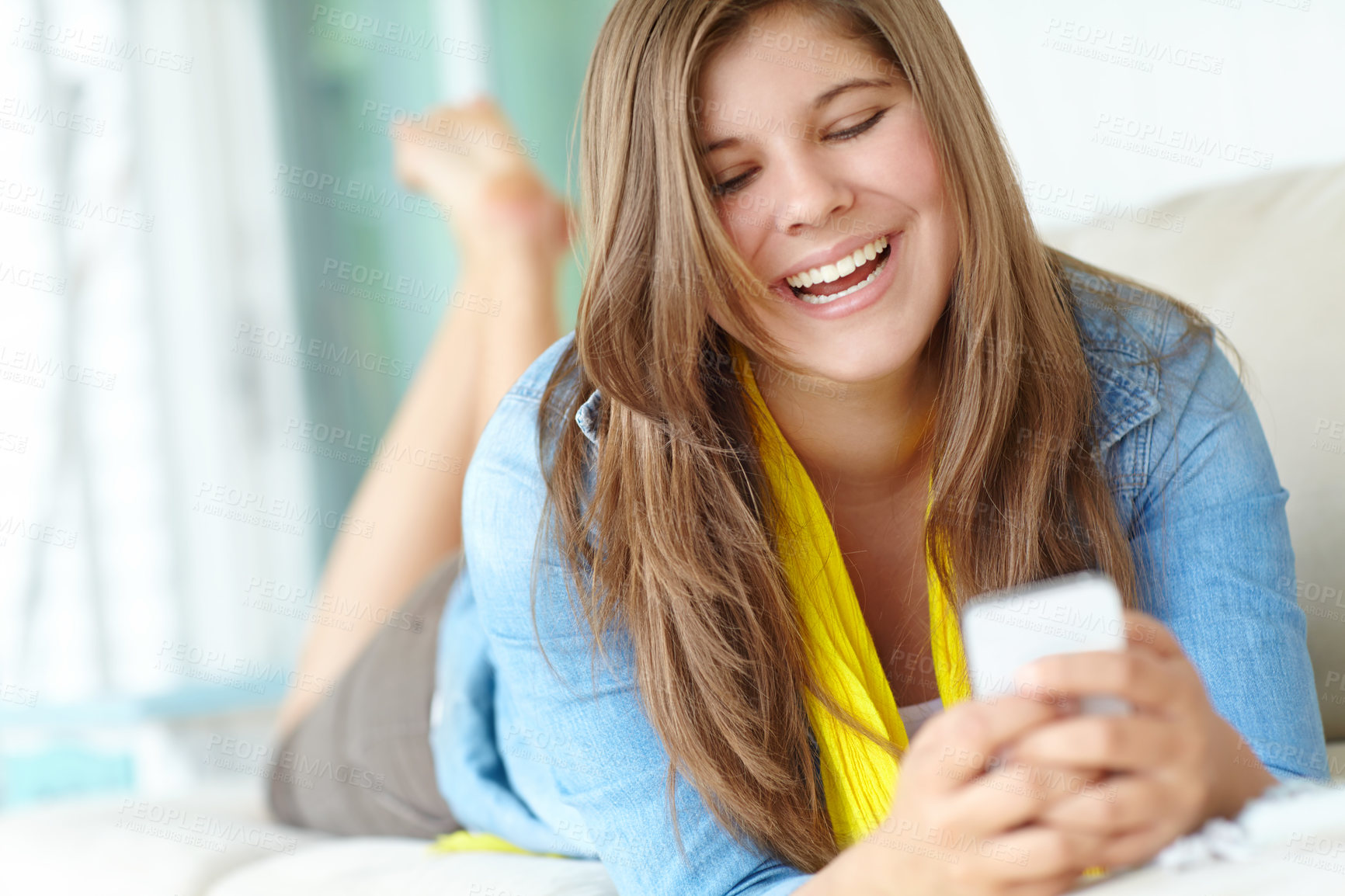 Buy stock photo Girl, laughing and relax on phone in home, funny meme and joke on social media in living room. Female person, reading notification and online for communication on couch, texting and app to chat