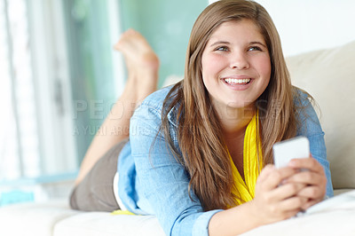 Buy stock photo Girl, thinking and relax with phone in home, funny meme and joke on social media in living room. Female person, reading notification and online for communication on couch, texting and app to chat