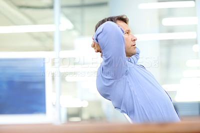 Buy stock photo Attractive businessman leaning back in a chair at the office