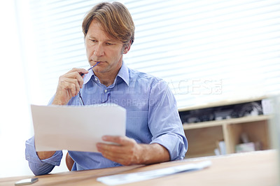 Buy stock photo Mature businessman thinking deeply while looking over documents