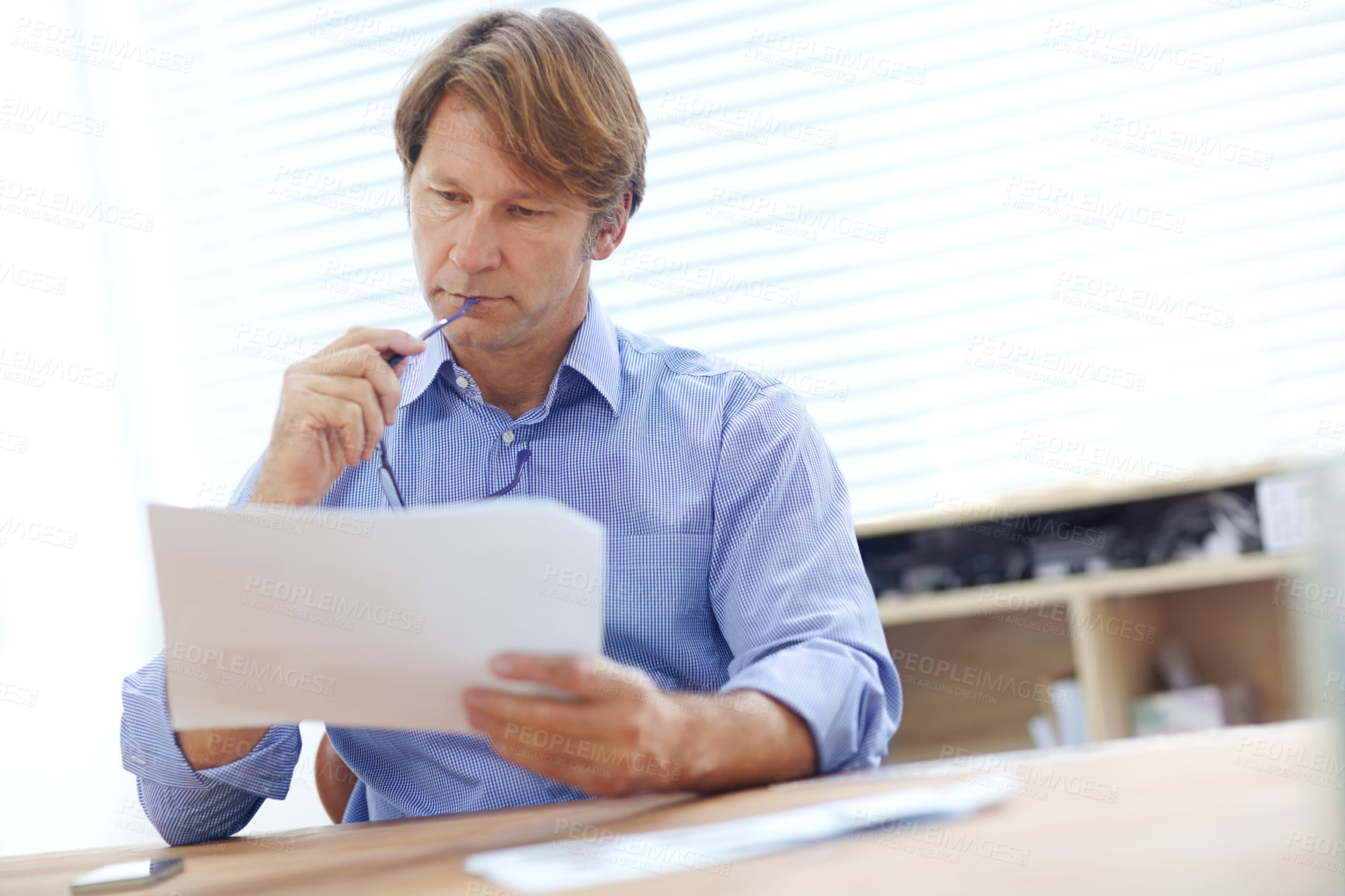 Buy stock photo Mature businessman thinking deeply while looking over documents