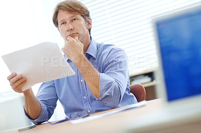Buy stock photo Mature businessman sitting at a desk thinking about business