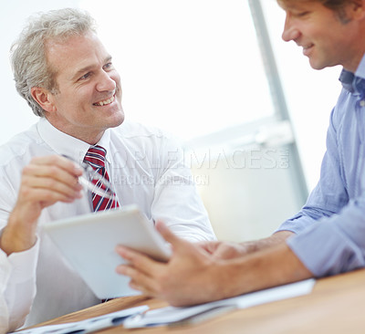 Buy stock photo Two male business associates having a meeting accompanied by a tablet