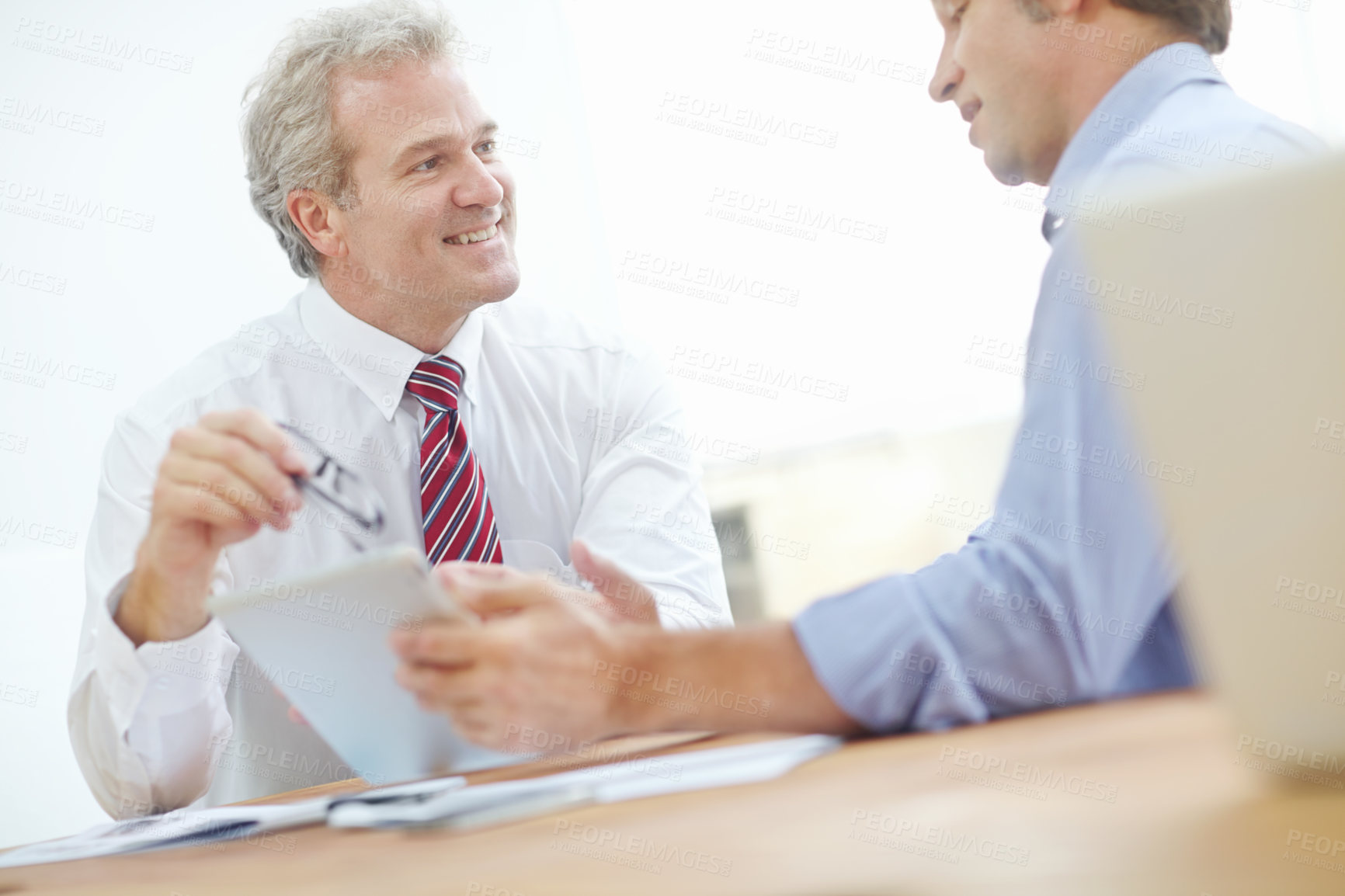 Buy stock photo Two male business associates sitting at a desk having a meeting
