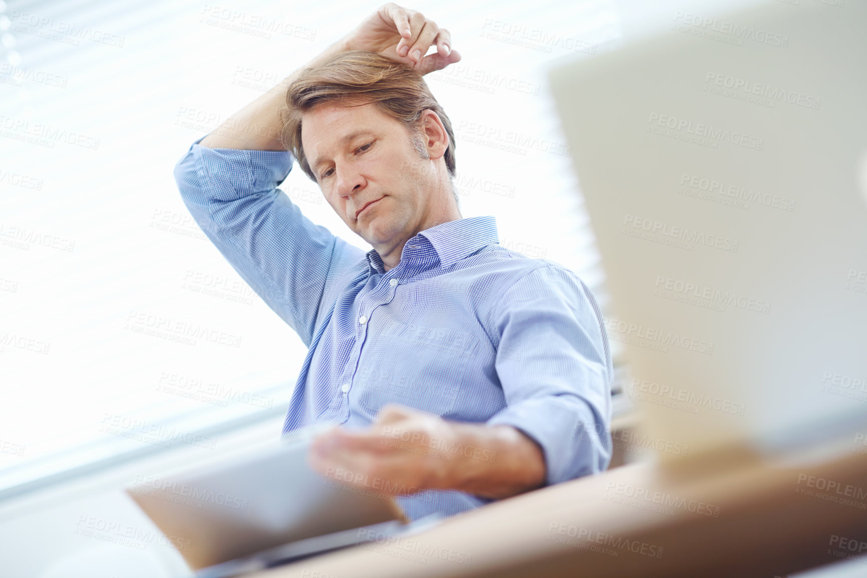 Buy stock photo Mature businessman thinking about the contents on a tablet