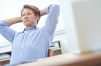 Buy stock photo Mature, attractive business associate sitting in an office with his hands behind his head