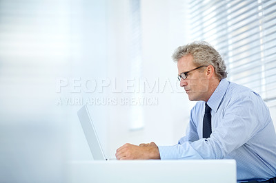 Buy stock photo Profile shot of a mature businessman thinking while sitting in front of his laptop