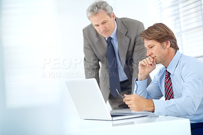 Buy stock photo Shot of two mature businessman working with a laptop