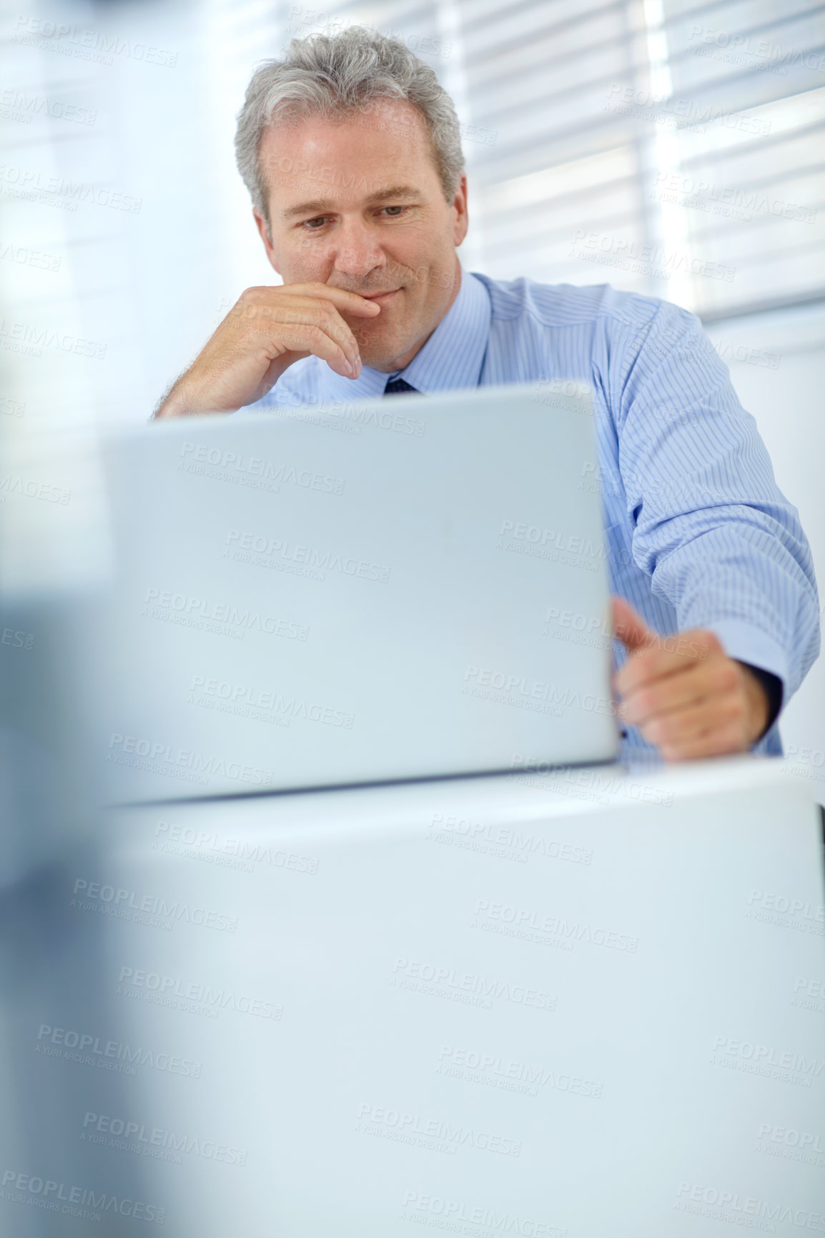 Buy stock photo Shot of a mature businessman thinking while sitting in front of his laptop