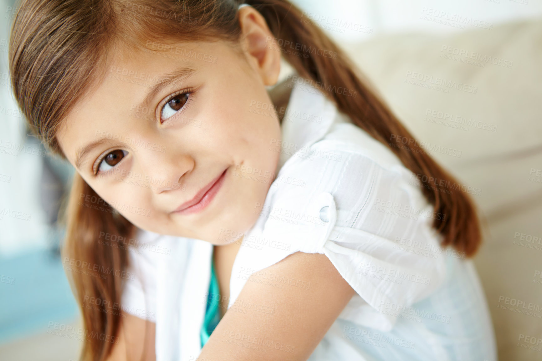 Buy stock photo Girl, confident or portrait of child on sofa for fun on weekend in living room of house or home. Smile, satisfaction and face of female kid alone on couch for happiness, comfort or childhood in Spain